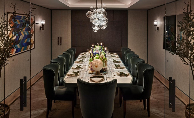Table with dim lighting with green chairs surrounding the table